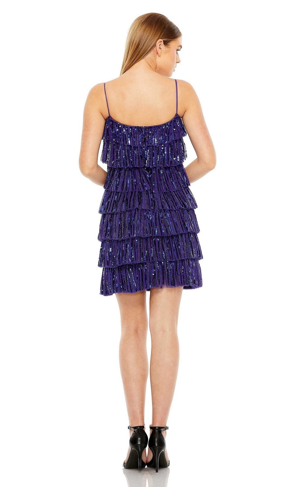 A woman, seen from behind, wears the Mac Duggal 23001 Short Ruffled Semi-Formal Dress—sleeveless and dark purple with sequins—paired with black heels, posed against a white background.